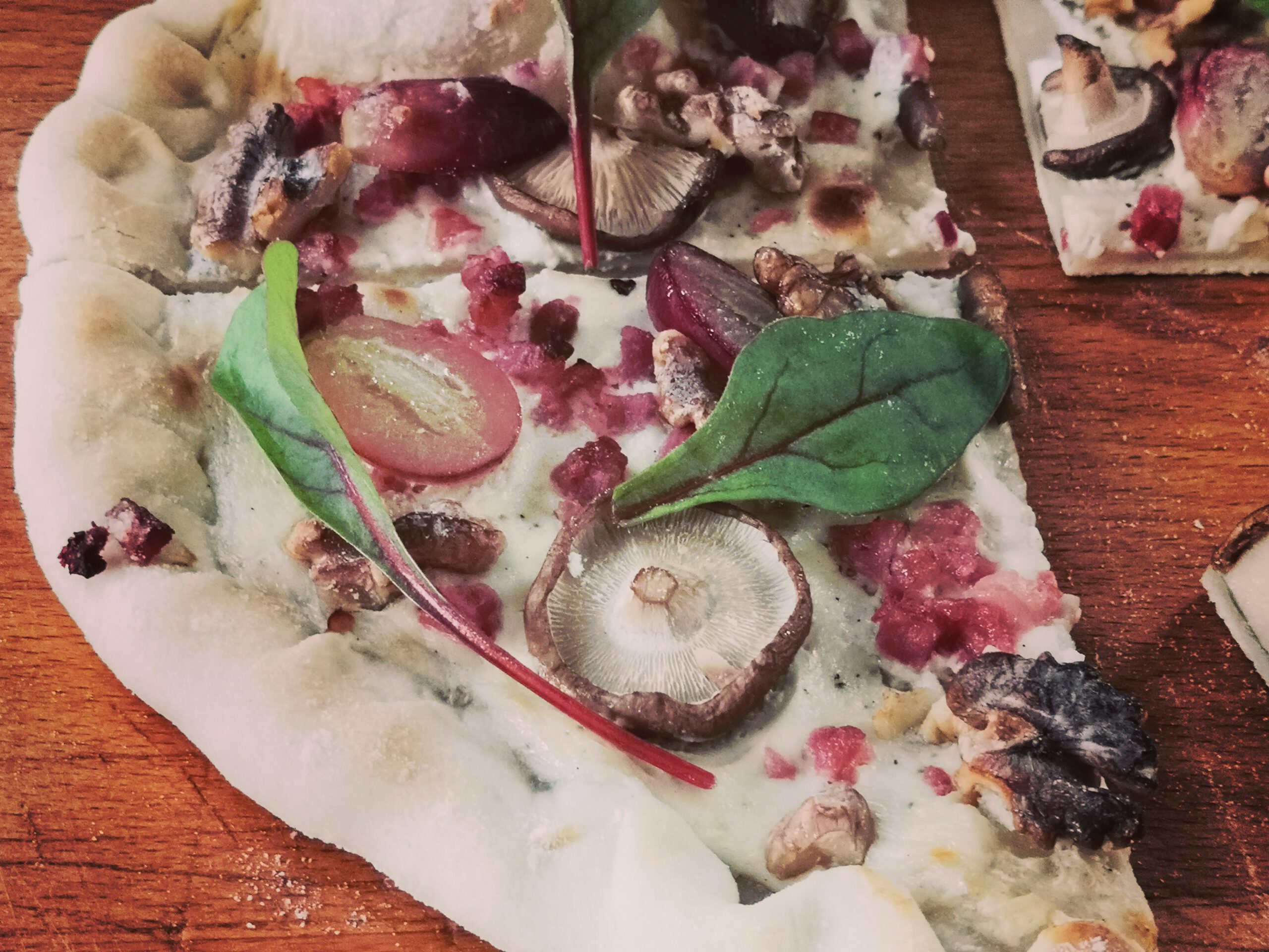 Flammkuchen mit Shiitake, Weintrauben, Mangold, Schinkenspeck, Walnüssen